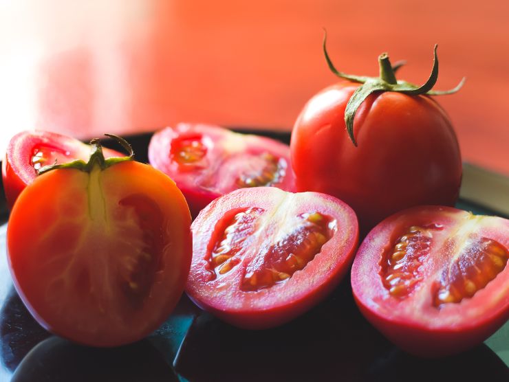 pomodori tagliati su piatto nero