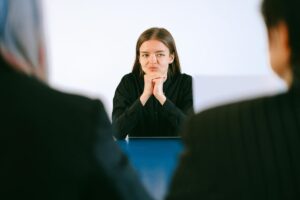 ragazza seduta di fronte a due persone durante un colloquio di lavoro