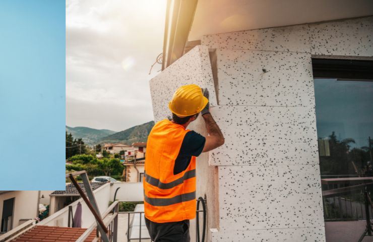 un uomo che mette il cappotto termico ad una casa